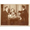 Trzej studenci podczas gry w karty na dawnej fotografii