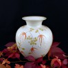 Orientalne kwiaty o pomarańczowej barwie oraz ozdobne tłoczenia zdobią pulchny brzusiec wazonu