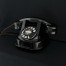 Czarny telefon w metalowej obudowie z I połowy XX wieku