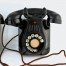 Wiszący teklefon z połowy XX wieku w czarnej obudowie