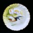 Talerz przedstawia ptaka wodnego prawdopodobnie czajkę przelatującą nad liliami wodnymi