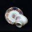 Porcelana w kolorze kości słoniowej ozdobiona została neobarokowym wzorem oraz kwiatową malaturą