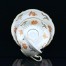 Neobarokowe, złote ornamenty oraz róża w kolorze pomarańczowym zdobią kremową porcelanę Rosenthal
