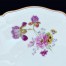 Paterę zdobi wielobarwna kompozycja kwiatowa wśród której cudowny irys i inne polne kwiatki