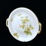 Znana kompozycja kwiatów melisy w barwach żółto-zielonych zdobi ten talerz