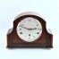 gabinetowy zegar w drewnianej obudowie z czytelną srebrzystą tarczą