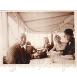 Grupa znajomych siedzących w restauracji na dawnej czarno białej fotografii