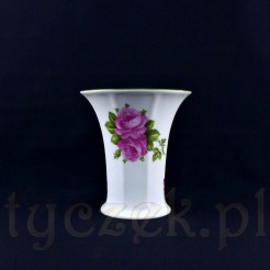 Uroczy wazon ze śnieżnobiałej porcelany ozdobiony został kompozycją różaną