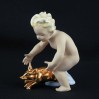 Putto łapię złotą świnkę- kolekcjonerska figurka szczęścia