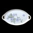 Na śnieżnobiałej porcelanie umieszczona została pastelowa kompozycja kwitnących kwiatów jeżyny