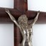 Zbliżenie na metalową pasyjkę Chrystusa na drewnianym krzyżu