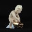 Wyjątkowa figurka porcelanowa łącząca motyw putta ze świnką szczęścia. Oryginalne złocenia, błękitna podstawa. Certyfikat autentyczności