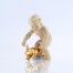 Porcelanowa figurka putta ze złoconą świnką szczęścia na błękitnej podstawie, antyk