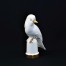 Biały ptak siedzący na postumencie z lekko odwróconą główką