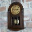 Salonowy zegar z zaokrągloną górą w drewnainej obudowie